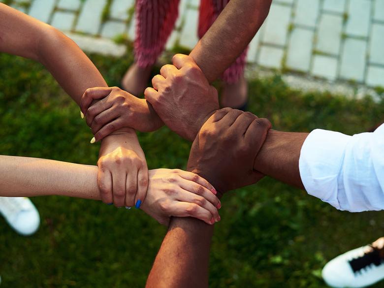 A group of people putting their hands in the middle